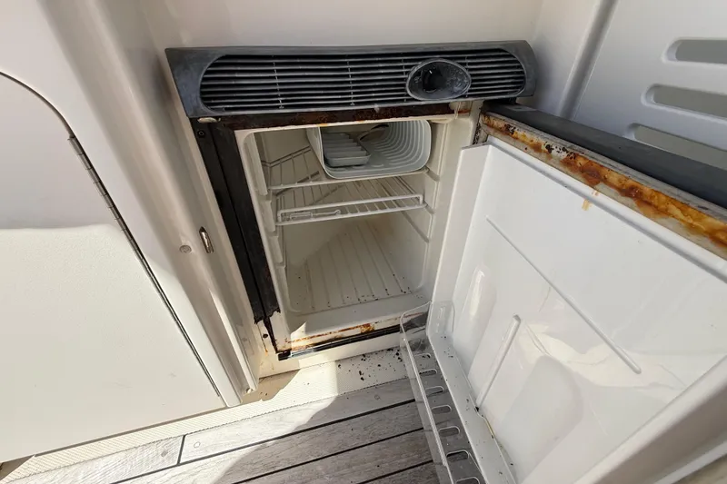 Slide: The Image of Open refrigerator on 2008 Sea Ray 38 Sundancer boat, showing interior shelves and rust. - 123