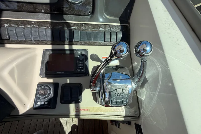 Slide: The Image of Control panel of a 2008 Sea Ray 38 Sundancer boat with throttle levers and navigation display. - 108