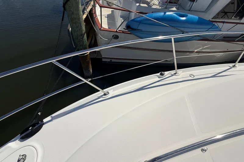 Slide: The Image of 2008 Sea Ray 38 Sundancer yacht docked, featuring sleek deck and railing design. - 7