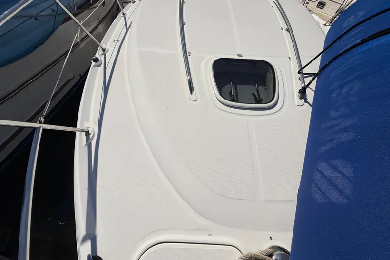 Slide: The Image of 2008 Sea Ray 38 Sundancer yacht deck with hatch and railing, docked beside another boat. - 11
