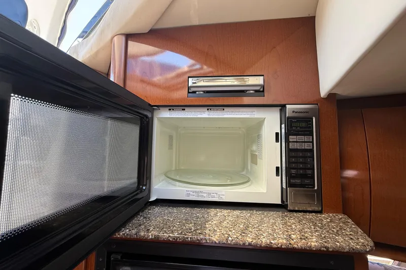 Slide: The Image of Microwave in 2008 Sea Ray 38 Sundancer yacht kitchen, featuring wood cabinetry and granite countertop. - 65