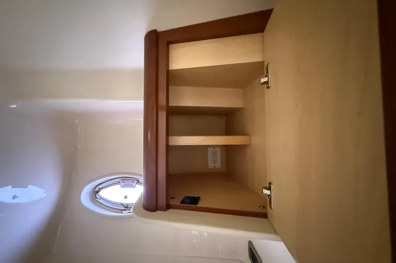 Slide: The Image of Cabinet interior on 2008 Sea Ray 38 Sundancer yacht, featuring shelves and a porthole. - 55