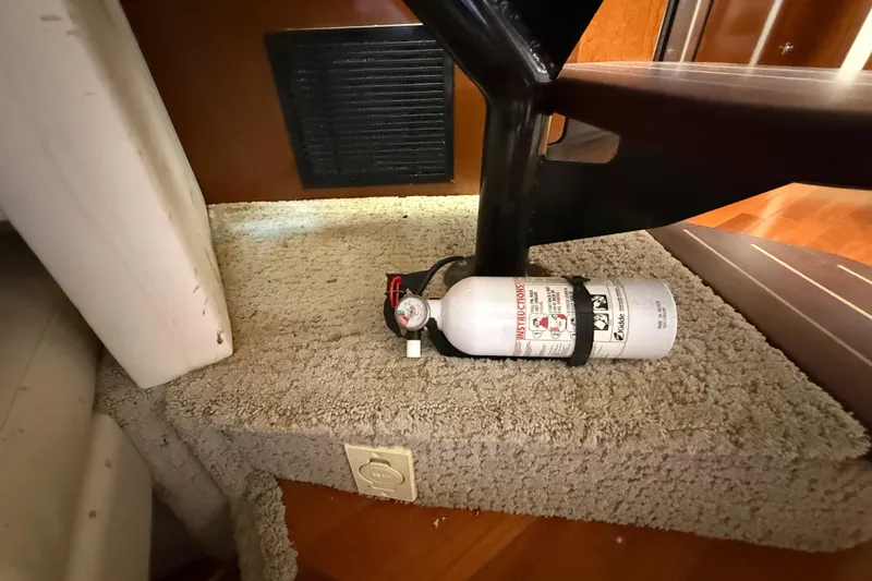 Slide: The Image of Fire extinguisher on carpeted step inside 2008 Sea Ray 38 Sundancer boat. - 86