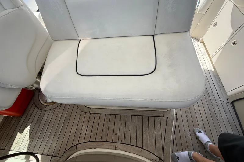 Slide: The Image of 2008 Sea Ray 38 Sundancer boat interior with white seating and wooden flooring. - 111