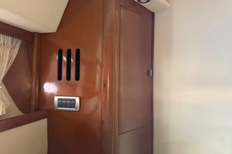 Slide: The Image of Interior cabin of 2008 Sea Ray 38 Sundancer with wooden paneling and control switches. - 42