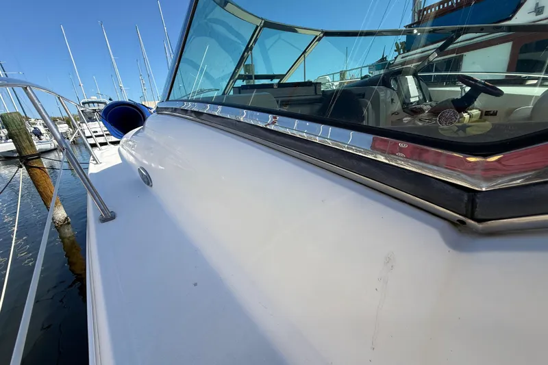 Slide: The Image of 2008 Sea Ray 38 Sundancer yacht docked at marina, showcasing sleek design and windshield. - 26