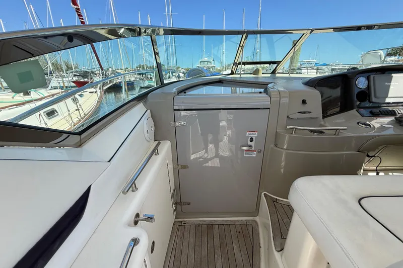 Slide: The Image of 2008 Sea Ray 38 Sundancer cockpit with helm, marina view, and sleek design. - 96