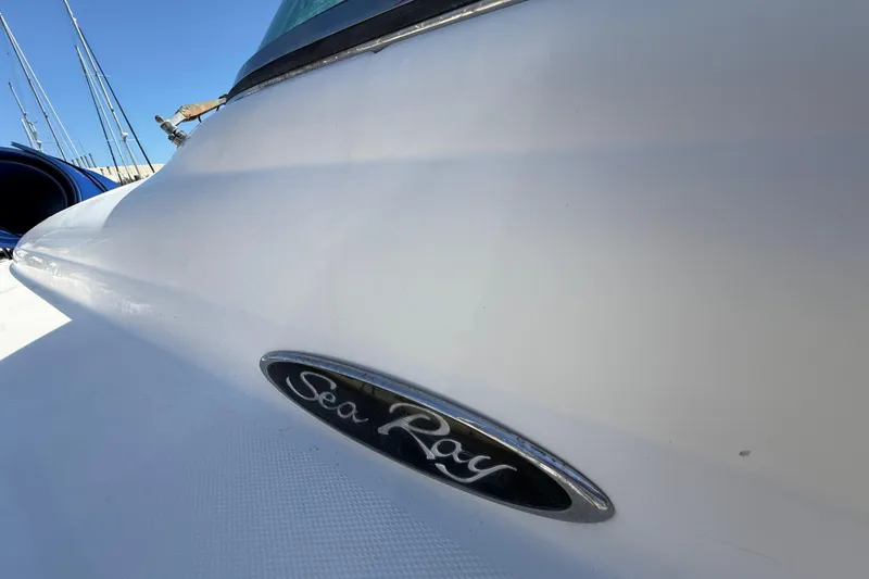 Slide: The Image of Close-up of a 2008 Sea Ray 38 Sundancer boat with logo, under clear blue sky. - 25