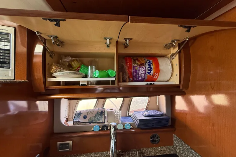 Slide: The Image of 2008 Sea Ray 38 Sundancer kitchen cabinet with plates, cups, and paper towels. - 62