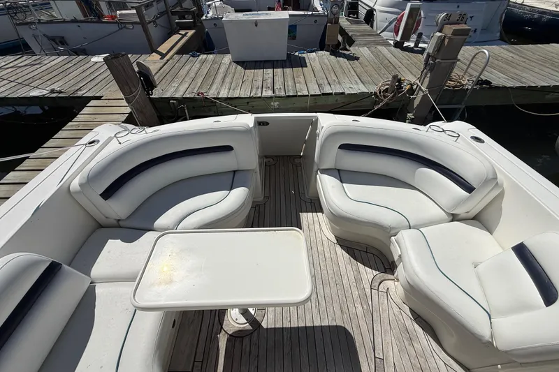 Slide: The Image of 2008 Sea Ray 38 Sundancer boat interior with white seating and table at dock. - 133
