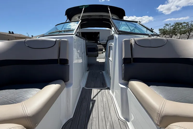 Slide: The Image of 2013 Formula 310 Bowrider boat interior with seating and open deck under clear sky. - 50