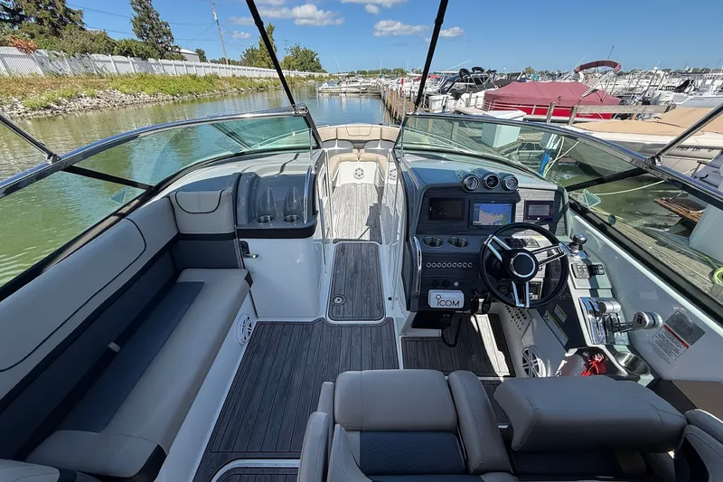 Slide: The Image of 2013 Formula 310 Bowrider interior with modern dashboard, steering wheel, and seating in a marina setting. - 27