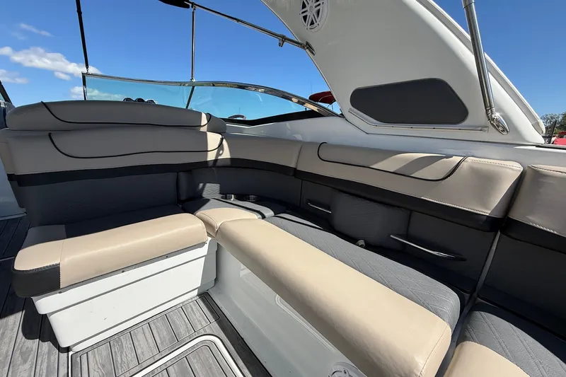 Slide: The Image of 2013 Formula 310 Bowrider interior seating with beige and gray upholstery under clear blue sky. - 20