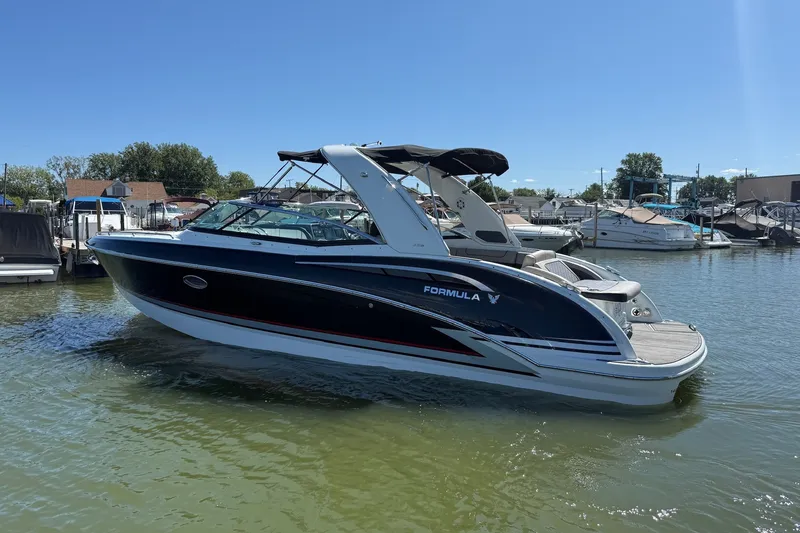 The Image of 2013 Formula 310 Bowrider boat docked in a marina under clear blue skies. - 0