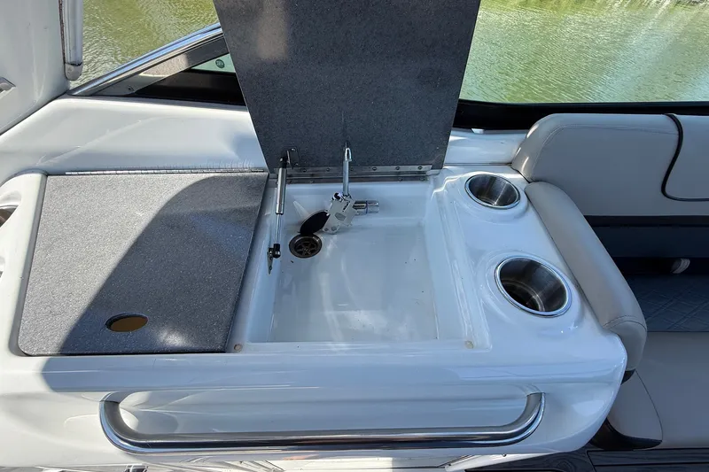 Slide: The Image of 2013 Formula 310 Bowrider boat interior with open storage compartment and cup holders. - 25