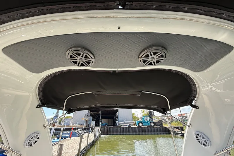 Slide: The Image of 2013 Formula 310 Bowrider boat interior with speakers and canopy at a dock. - 52