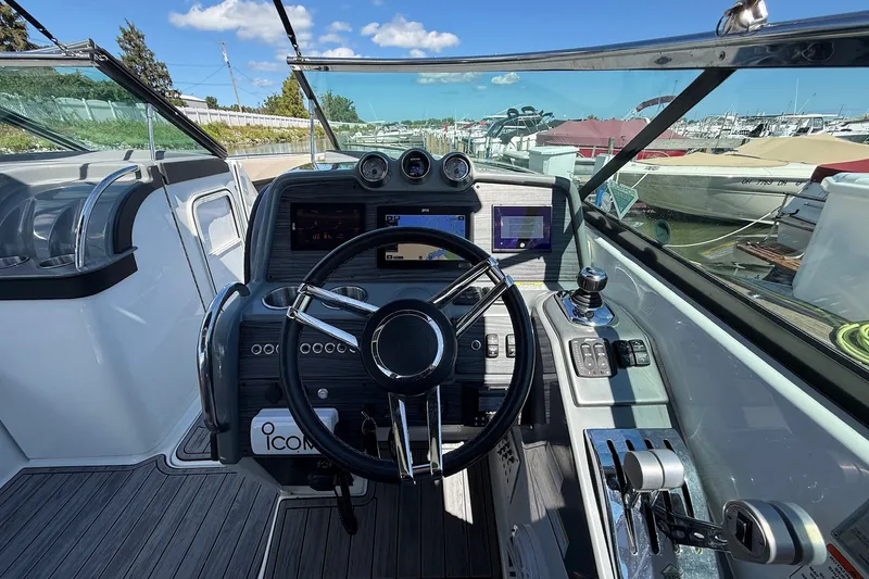 Slide: The Image of 2013 Formula 310 Bowrider helm with steering wheel and control panel, docked at marina. - 32