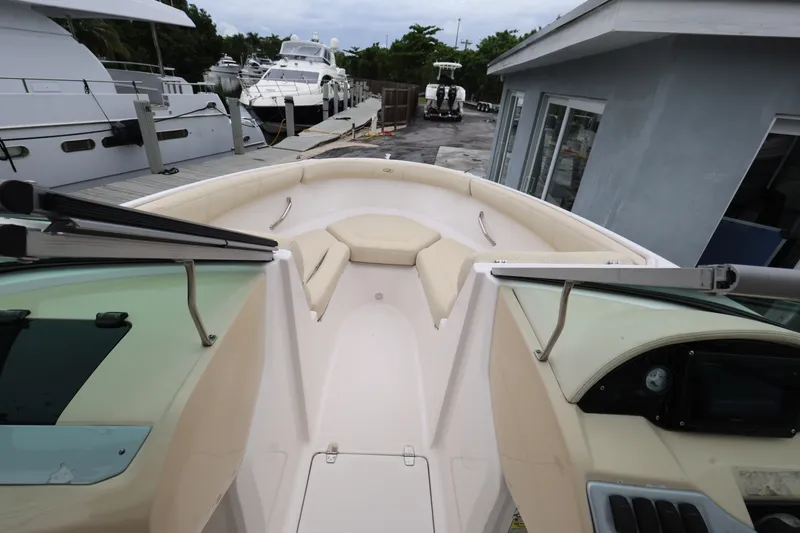 Slide: The Image of 2020 Regal 21 OBX boat interior with beige seating at a marina. - 13