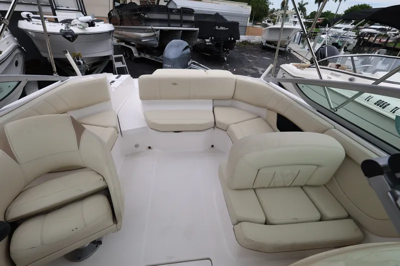 Slide: The Image of 2020 Regal 21 OBX boat interior with beige seating in a marina setting. - 17