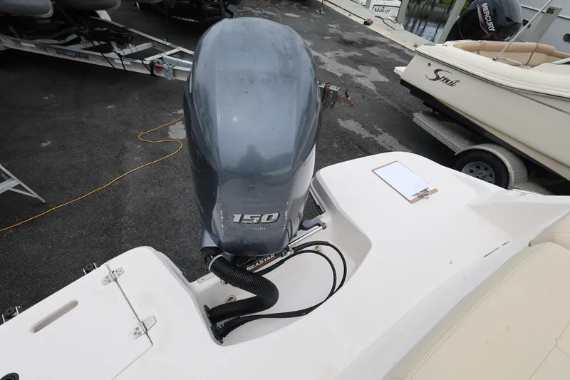 Slide: The Image of 2020 Regal 21 OBX boat with a 150 horsepower outboard motor, docked near other boats. - 23