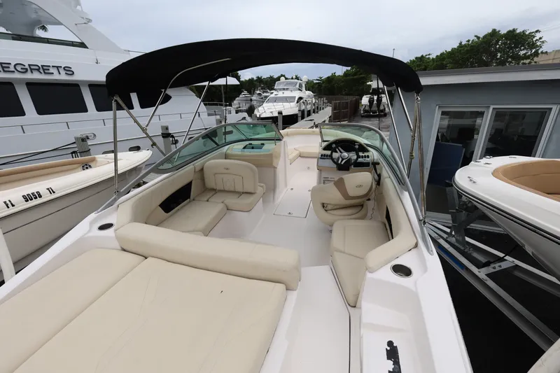 Slide: The Image of 2020 Regal 21 OBX boat with beige seating and black canopy, docked near other boats. - 8