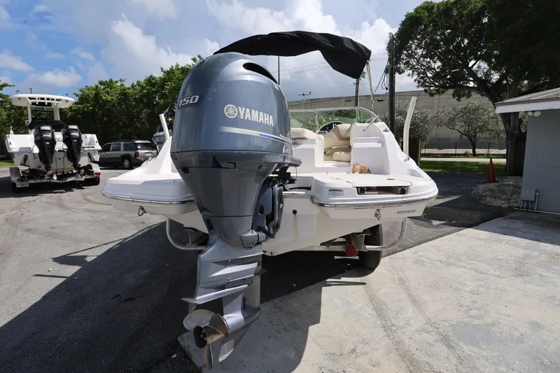 Slide: The Image of 2020 Regal 21 OBX boat with Yamaha 150 outboard motor, parked outdoors. - 3