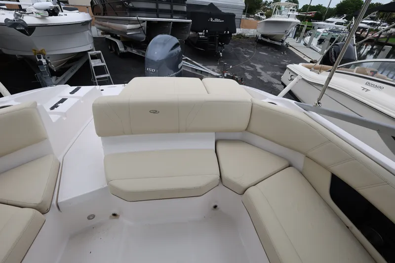 Slide: The Image of 2020 Regal 21 OBX boat interior with beige seating, docked among other boats. - 18