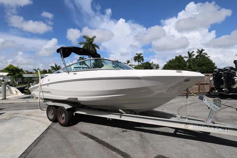 The Image of 2020 Regal 21 OBX boat on trailer under blue sky with palm trees. - 0