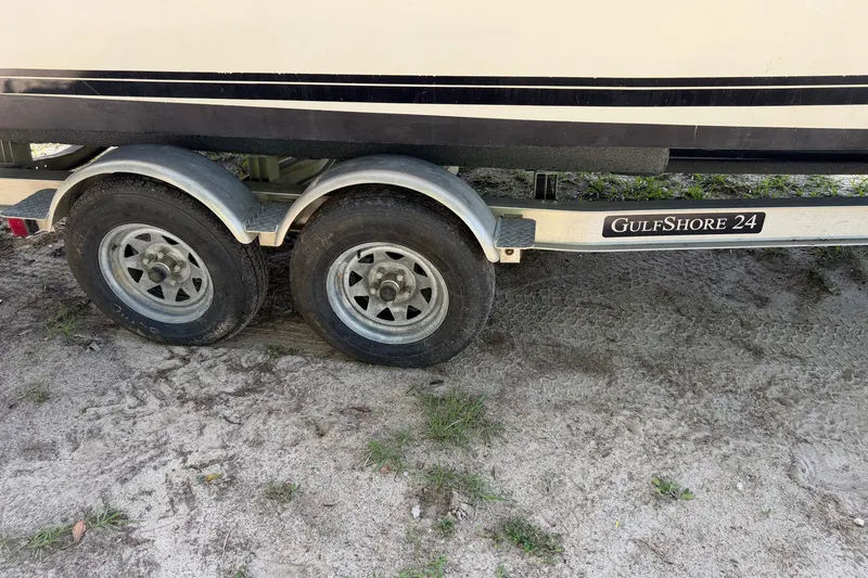 Slide: The Image of Een dubbelassige boottrailer met het label "GulfShore 24" staat op zanderige grond. - 8