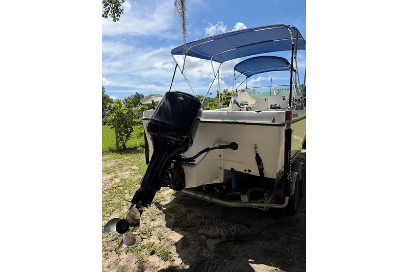 Slide: The Image of Een Seaswirl Striper 2301 Walkaround OB uit 1999 met buitenboordmotor en blauwe bimini-top, op een trailer. - 3