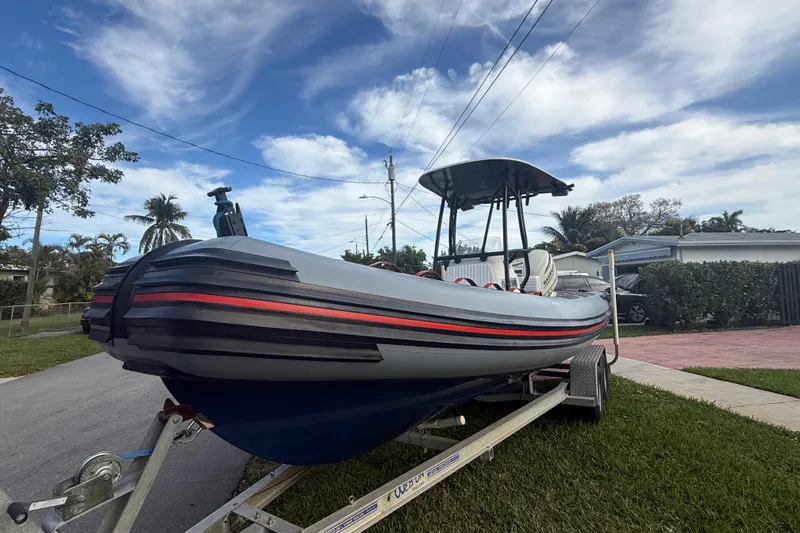 Slide: The Image of 1998 Novamarine SEVEN HD boat on trailer, parked in residential area under blue sky. - 1