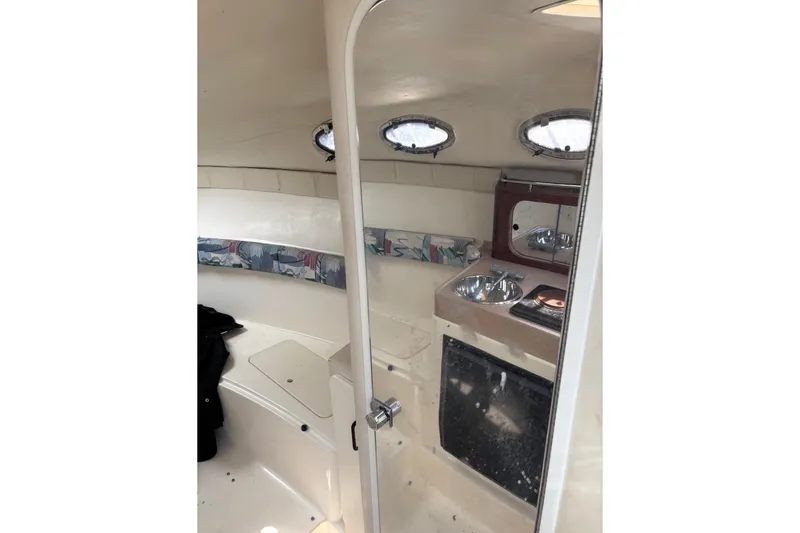 Slide: The Image of Interior of a 1997 Donzi 255 LXC boat with kitchenette and seating area. - 15