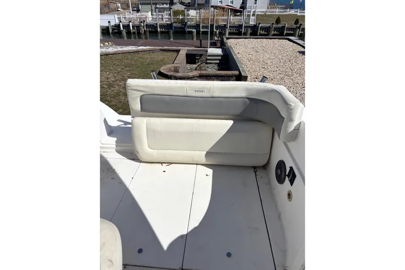 Slide: The Image of 1997 Donzi 255 LXC boat interior with white seating and dock view. - 18
