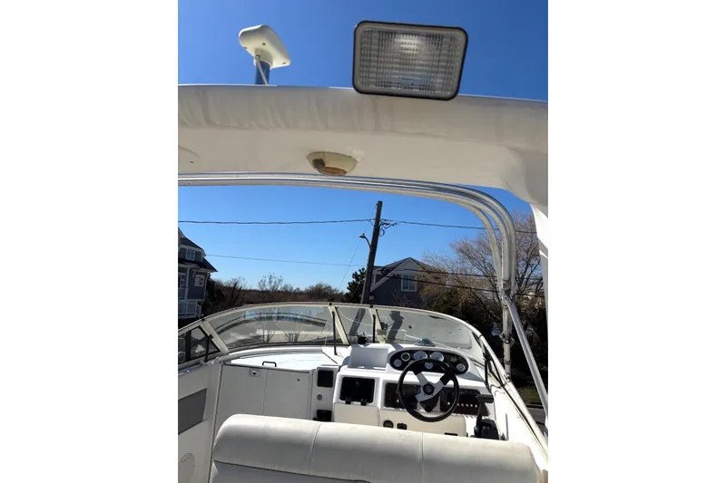 Slide: The Image of 1997 Donzi 255 LXC boat cockpit with steering wheel and dashboard under clear blue sky. - 20