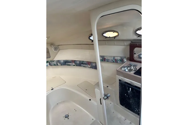 Slide: The Image of 1997 Donzi 255 LXC boat interior with kitchenette and seating area. - 23
