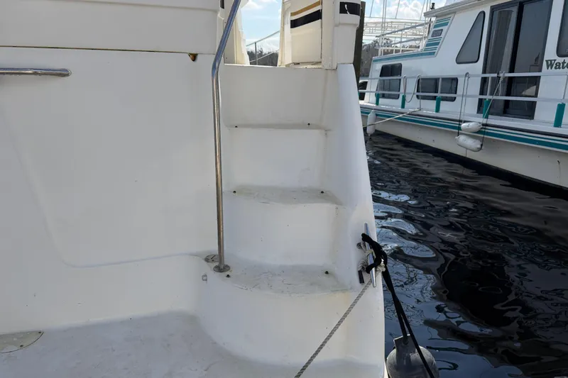 Slide: The Image of 1997 Sea Ray 370 Aft Cabin boat steps with railing, docked near water. - 8
