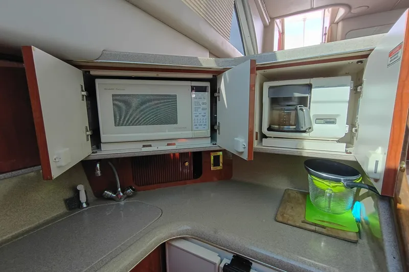 Slide: The Image of 1997 Sea Ray 370 Aft Cabin kitchen with microwave, coffee maker, and countertop accessories. - 78