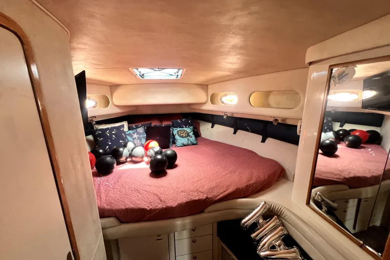 Slide: The Image of Cozy cabin interior of 1997 Sea Ray 450 Express Bridge with bed and decorative pillows. - 36