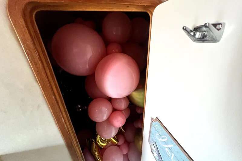 Slide: The Image of Ein Bootsschrank voller rosa und goldener Luftballons. - 43