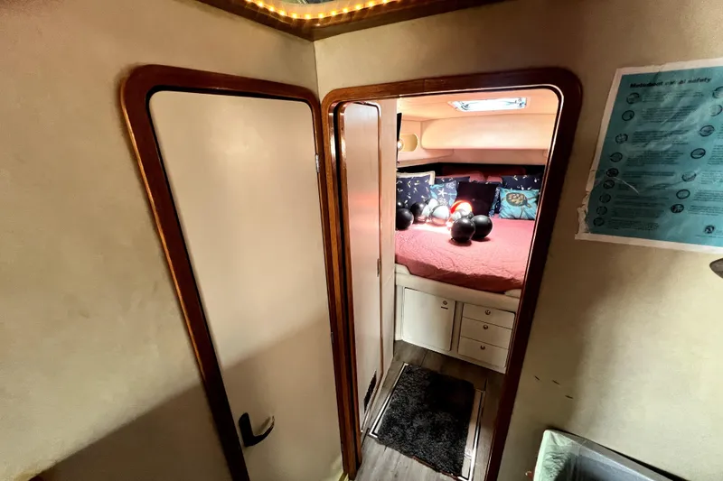 Slide: The Image of Interior cabin of 1997 Sea Ray 450 Express Bridge with cozy bed and decorative pillows. - 35