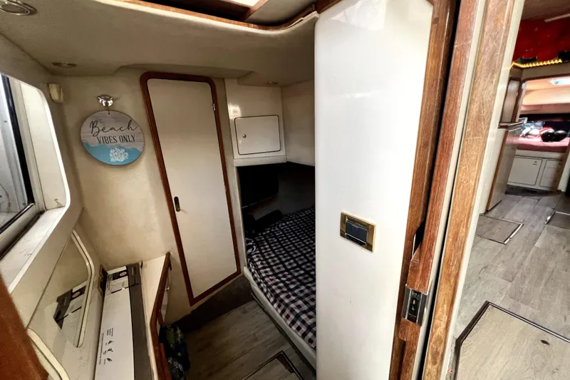 Slide: The Image of Interior of 1997 Sea Ray 450 Express Bridge with cozy cabin and "Beach Vibes Only" sign. - 39