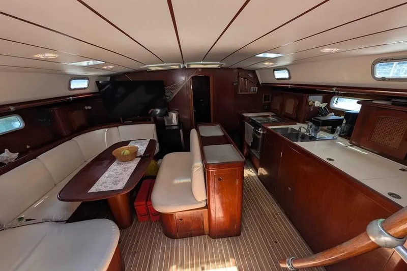 Slide: The Image of Interior of a 1996 Beneteau 50 yacht with elegant wood finish and spacious seating. - 72