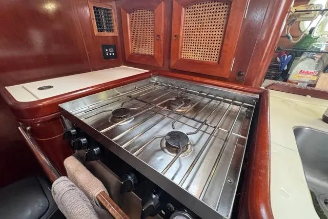 Slide: The Image of Galley kitchen in 1996 Beneteau 50 sailboat with stove and wooden cabinetry. - 84