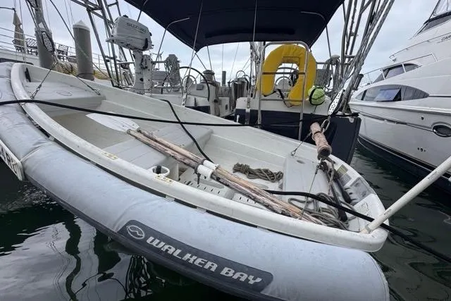 Slide: The Image of Inflatable Walker Bay dinghy on a 1996 Beneteau 50 sailboat, docked in a marina. - 2