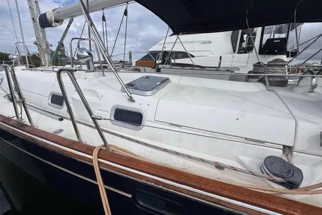 Slide: The Image of 1996 Beneteau 50 sailboat with white deck and wooden trim, docked at marina. - 7