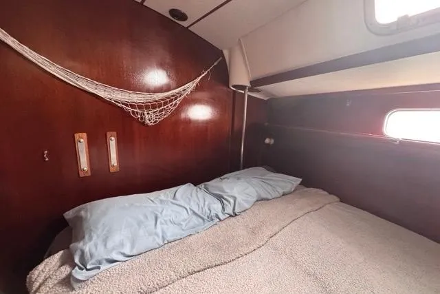 Slide: The Image of Cozy cabin interior of 1996 Beneteau 50 sailboat with wooden paneling and bed. - 89