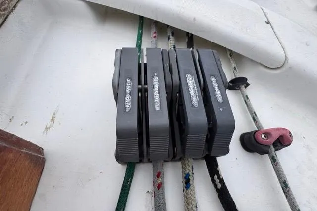 Slide: The Image of Deck hardware on a 1996 Beneteau 50 sailboat, featuring rope clutches and lines. - 55