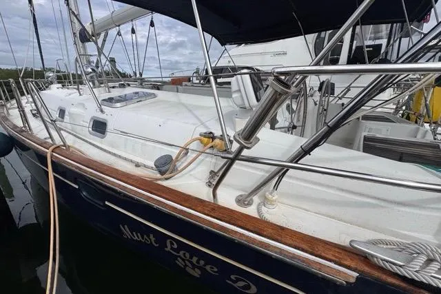 Slide: The Image of 1996 Beneteau 50 sailboat docked, featuring sleek white deck and polished wood accents. - 6