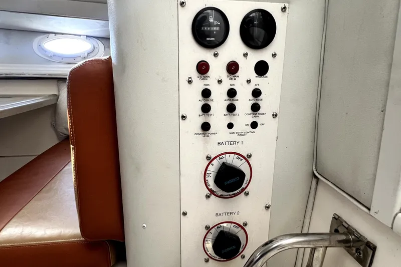 Slide: The Image of Control panel of a 1996 Wellcraft 330 Coastal boat, featuring battery switches and gauges. - 58