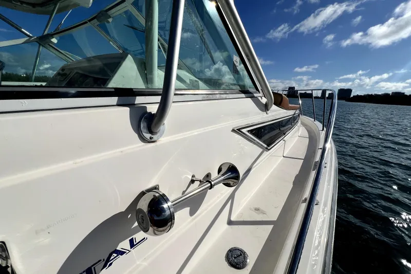 Slide: The Image of 1996 Wellcraft 330 Coastal boat on water, sunny day, sleek design, stainless steel railings. - 35